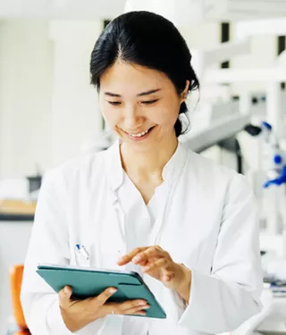 A dentist reading information from a digital tablet in a lab